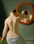 Naked woman doing her hair before a mirror