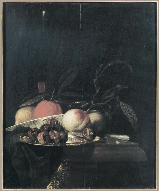 A lemon and orange in a porcelain bowl, a glass of wine, dates on a silver plate, an apple, a peach and a knife, all on a partially draped table