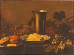 Still life of fruit with bread, butter and a silver cup