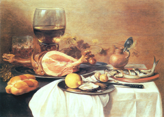 A ham, a herring, oysters, a lemon, bread, onions, grapes and a "roemer" (wine glass of that period) on a table by Pieter Claesz
