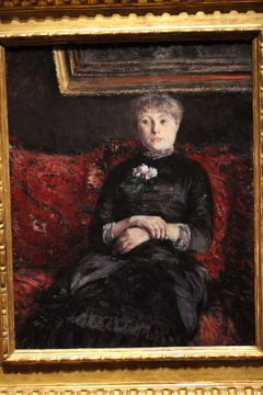 Woman Seated on a Red-Flowered Sofa