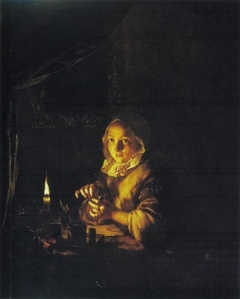 Young woman winding up a watch by candlelight