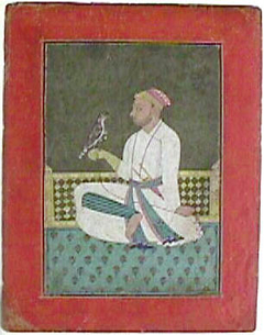 A Pahari raja seated on a terrace holding a hawk