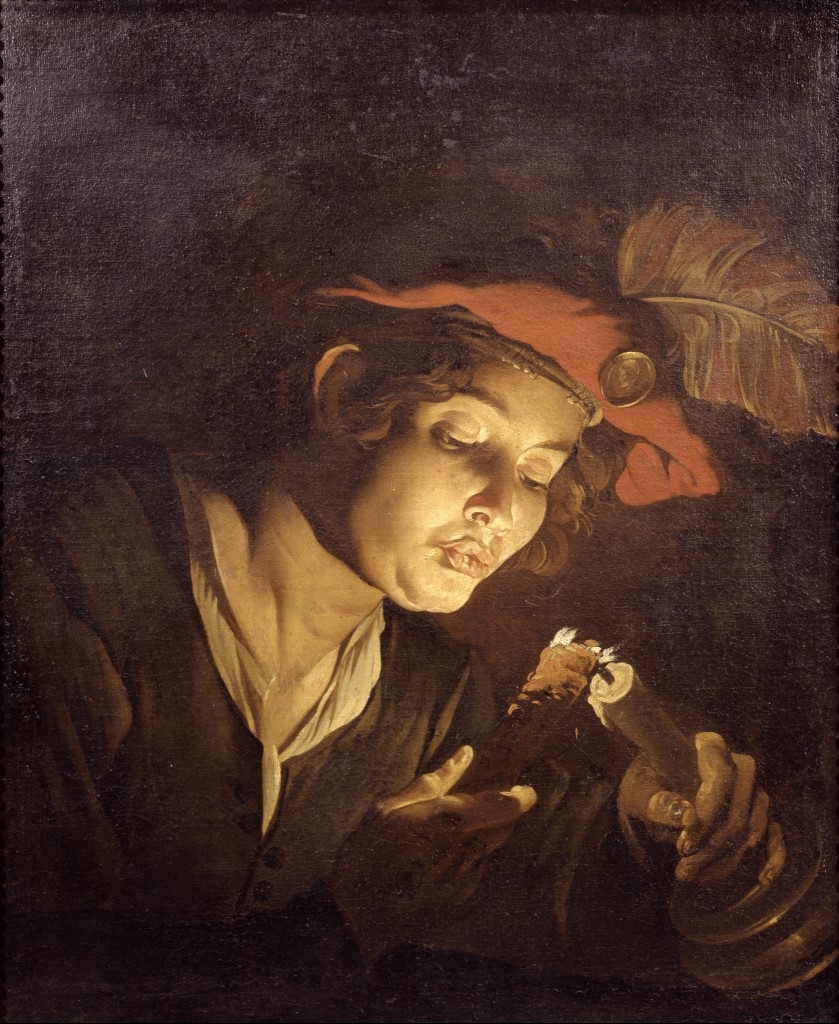 Boy lighting a candle from a wick